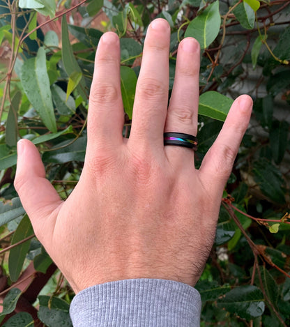 Rainbow wedding band on hand, showing black Tungsten exterior with rainbow stripe.