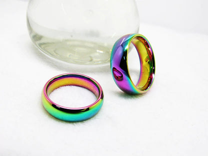 Pair of rainbow wedding rings on a white background.