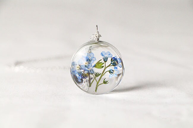 Real flower jewelry with genuine blue forget-me-nots preserved inside a glass pendant.