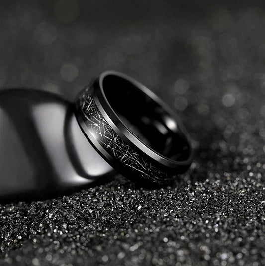 Ring with meteorite and black Tungsten on dark textured background.
