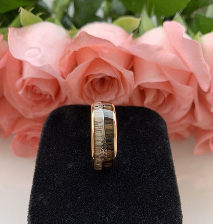 Rose gold Tungsten men's ring with genuine naturally-shed deer antler and natural Zebrawood inlay, featuring a silver arrow design and domed band.