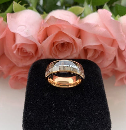 Rose gold Tungsten men's ring featuring a real wood inlay of natural Zebrawood alongside genuine naturally-shed deer antler, with a silver arrow design and domed band.