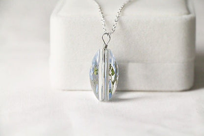 Side view of the pendant showing the clear glass and silver wire.