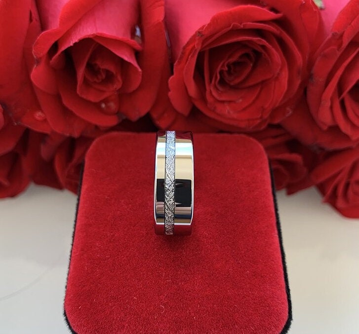 Silver Tungsten men's ring featuring a Gibeon meteorite inlay and polished edges, with red roses in the background.