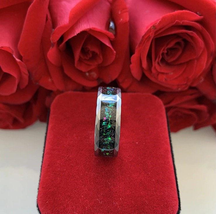 Silver Tungsten holographic galaxy opal ring with faceted design and red roses in background.