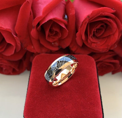 Tungsten meteorite ring with rose gold finish displayed against red roses.